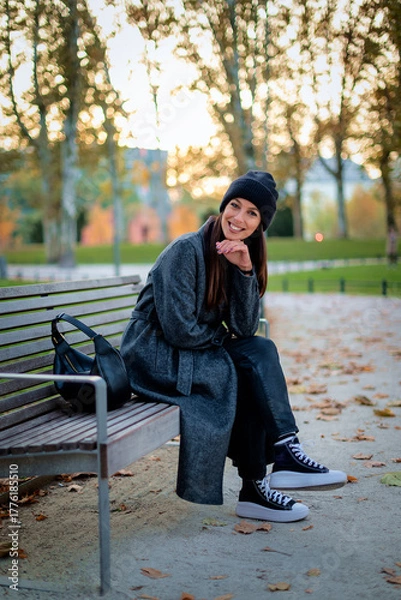 Obraz Full length of a confident middle-aged woman relaxing in a city park in an autumn day