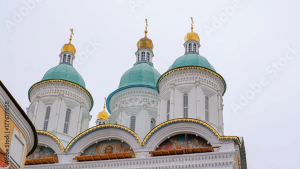 Fototapeta Close-up of elements of the domes of the Astrakhan Kremlin with a bell tower on a cloudy day. Astrakhan, Russia