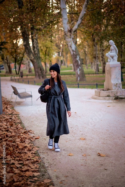 Obraz Smiling middle-aged woman wearing scarf and beanie in a park during the autumn season