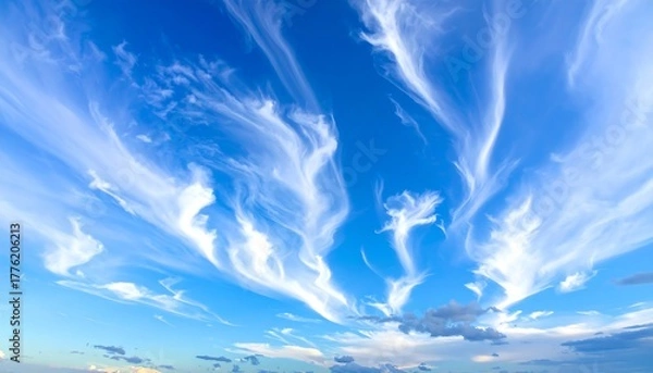 Fototapeta Expansive bright blue sky filled with wispy, streaking cirrus clouds, fading towards horizon