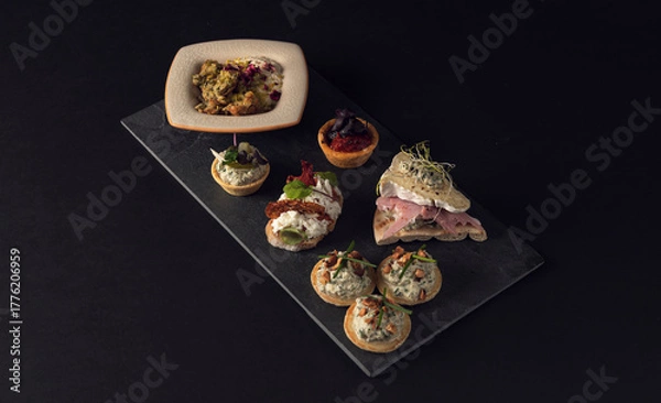 Fototapeta Top view of assorted canapes on slate board