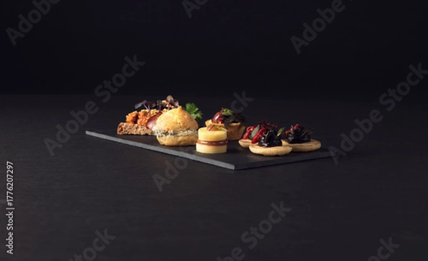 Fototapeta Refined platter of assorted canapes on slate board
