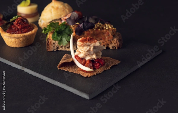 Fototapeta Gourmet platter of assorted creative appetizers on slate