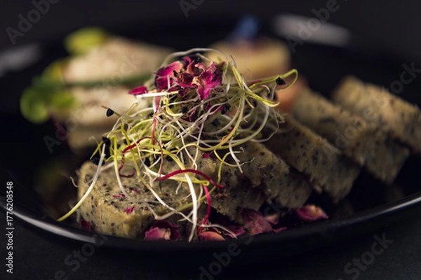 Fototapeta Close-up seed bread slices with microgreens and edible petals