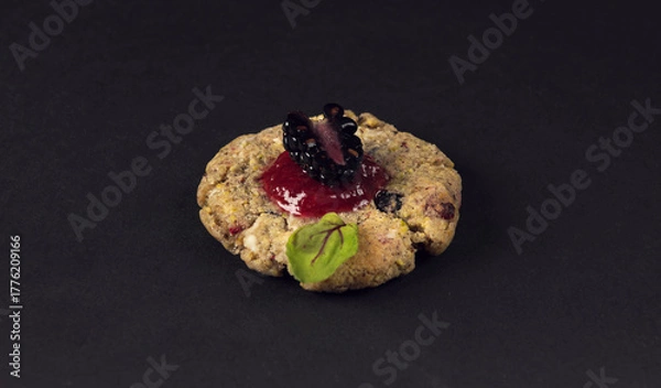 Fototapeta Single gourmet cookie with blackberry topping on dark background