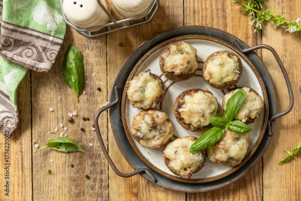 Obraz Stuffed mushrooms baked with cheese on rustic background. Top view flat lay background.  