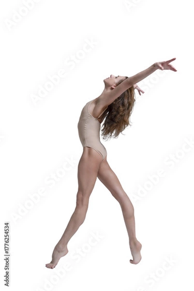 Fototapeta ballerina with beautiful feet poses in a photo studio, a ballerina in a leopard walks with her arms up