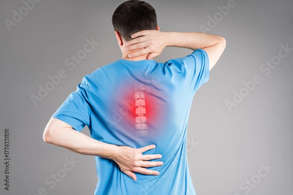 Obraz Intervertebral spine hernia, pain between the shoulder blades, man suffering from backache, spinal disc disease, gray background, health problems concept