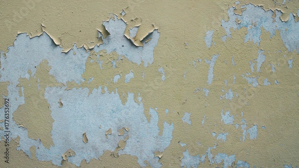 Fototapeta Close-up of old wall texture with peeling paint and cracks. Vintage surface of faded yellow and blue plaster showing weathered decay and flaking paint layers.