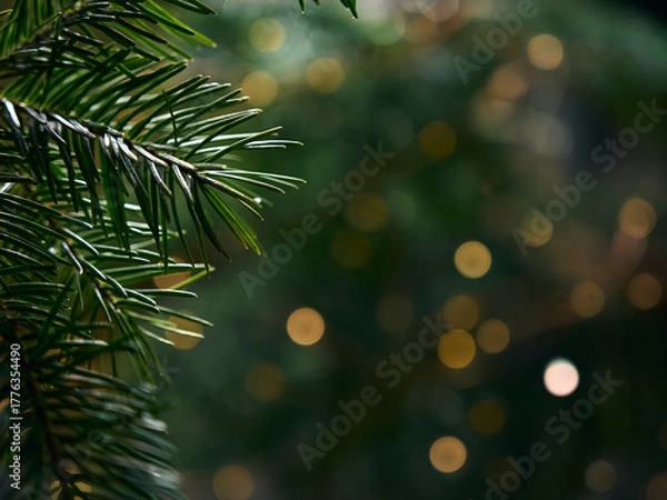 Fototapeta Green Christmas tree branch and yellow lights garlands blurred in bokeh
