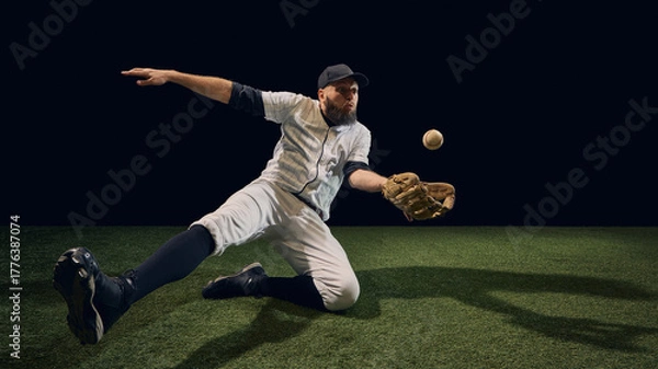 Fototapeta Baseball player sliding low fielding rolling ball with outstretched glove on turf. Concept of defensive reflex, fielding agility, tactical anticipation for sports education and motion reference.