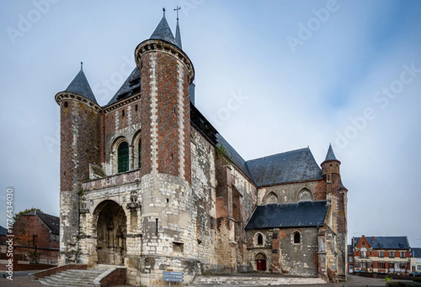 Fototapeta Slightly angled frontal shot of the fortified Église Saint-Martin de Montcornet, France. The church’s defensive tower and stone walls stand strong under soft daylight, showcasing medieval architecture