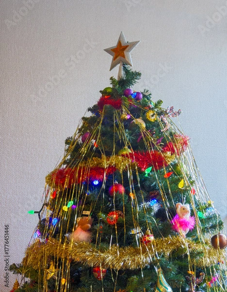 Obraz White-golden star and colourful balls with color electtric lights decorating top of Christmas tree