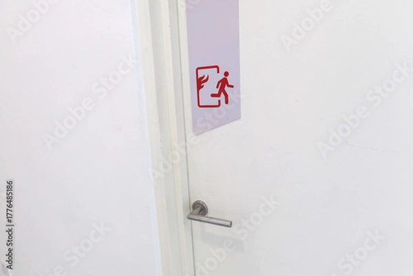 Fototapeta A fire door with a fire escape sign stuck on the surface for easy evacuation
