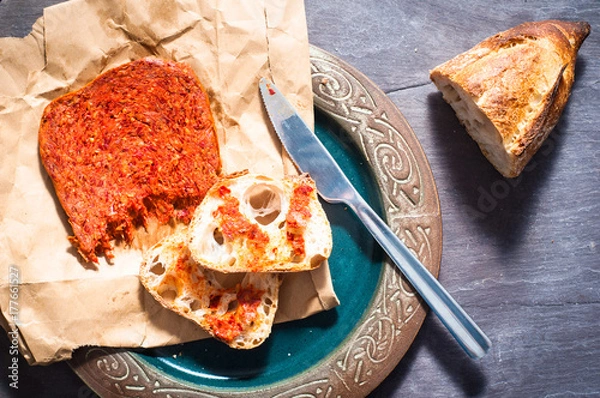 Obraz Pikantna włoska kiełbasa kalabryjska Nduja podawana z rustykalnym chlebem na zakwasie.