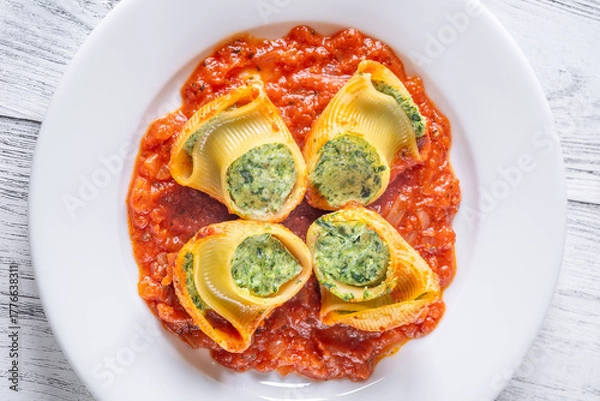 Fototapeta Plated lumaconi stuffed with ricotta and spinach topped with fresh tomato sauce