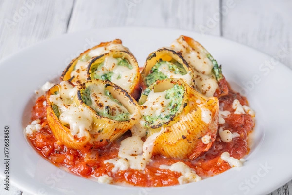 Fototapeta Plated lumaconi stuffed with ricotta and spinach topped with fresh tomato sauce