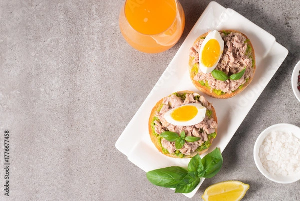Obraz Two delicious tuna open sandwiches with avocado and boiled eggs. Tuna toast.