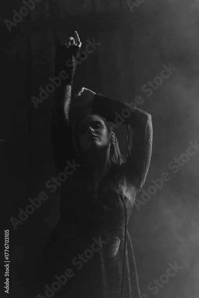 Fototapeta A mysterious woman stands in silhouette against a bright window, surrounded by dramatic smoke and shadows