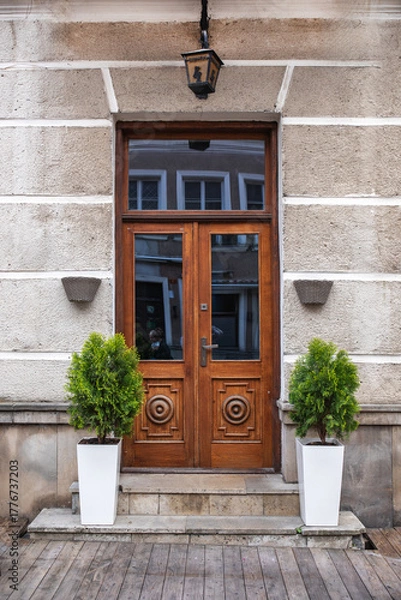 Fototapeta Designer entrance door to a country house. Modern design. Luxurious exterior. Facade of a modern building with modern doors.
