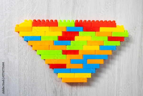 Fototapeta Assembled multi-colored plastic construction blocks lie on the floor.