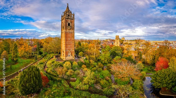 Fototapeta Cabot Tower surrounded by colorful autumn trees in Brandon Hill Park, with historic Bristol architecture in the background.