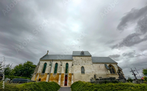 Fototapeta Bergnicourt, Rethel, Ardennes, Grand-Est, France, August, 28th, 2025,An ancient church stands resiliently against a dramatic backdrop of ominous and stormy clouds on the horizon