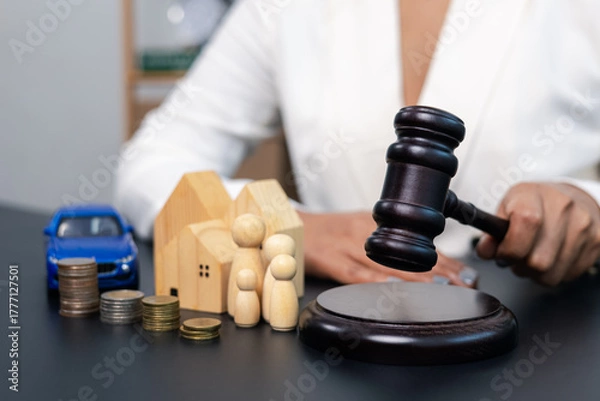 Fototapeta Judge hitting gavel with house family car and coins on table, legal decision and property concept