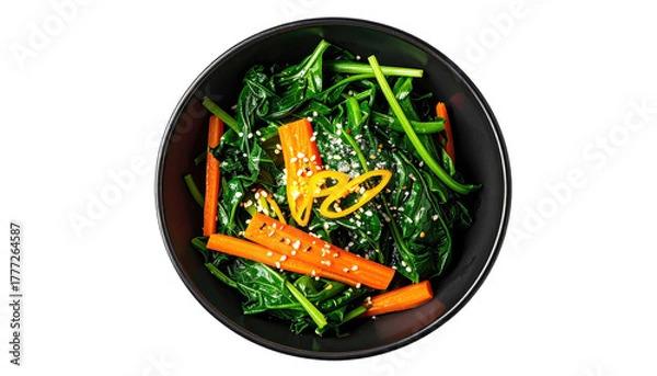 Fototapeta Green salad with carrots in black bowl, top view, on dark