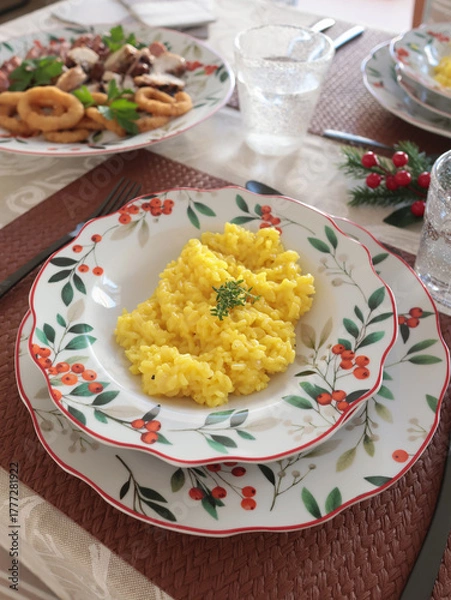 Obraz Table setting with bright tableware, berries, and twigs. Saffron risotto on plate. Traditional Italian food. Aesthetics and lifestyle. Interior design. 
