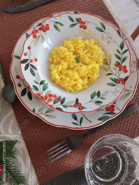 Obraz Table setting with bright tableware, berries, and twigs. Saffron risotto on plate. Traditional Italian food. Aesthetics and lifestyle. Interior design. 