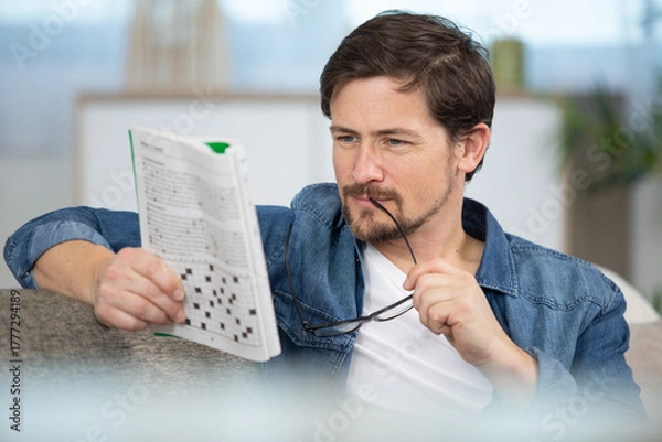 Fototapeta man contemplating clue in puzzle book