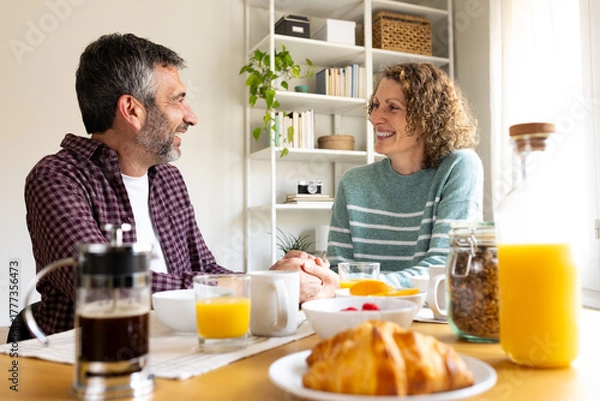 Obraz Happy couple enjoying a relaxed breakfast together at home
