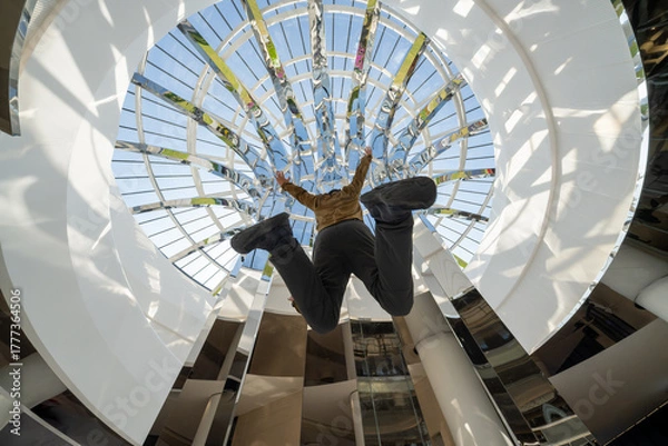Fototapeta Person Jumping Through Circular Skylight Low Angle View