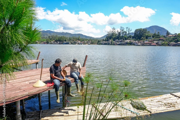 Fototapeta Two Friends Relax by Lake on Summer Day Enjoying Peaceful Scenery and Fresh Air