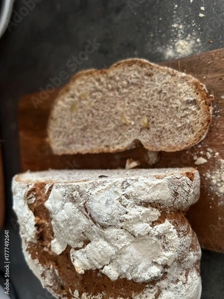 Fototapeta freshly baked sourdough bread sliced on wooden cutting board, directly above
