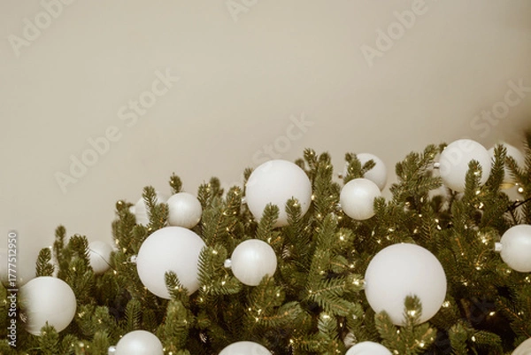Fototapeta Christmas tree with white ornaments against a blurred background of lights