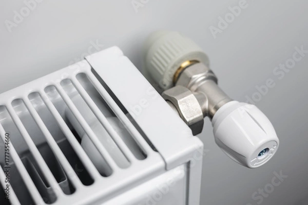 Fototapeta A steel panel heating radiator is placed under the windowsill on a white