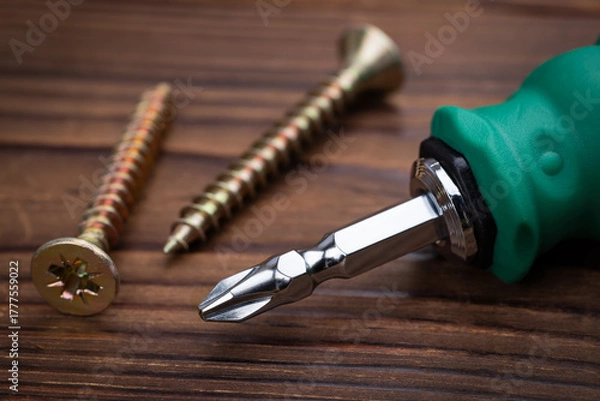 Obraz screwdriver and screws on wooden background close up