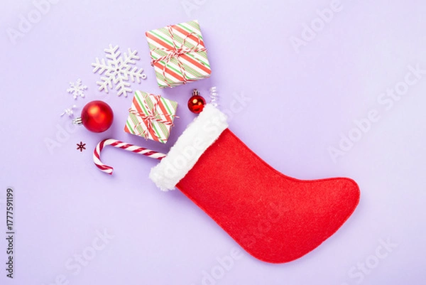 Obraz Christmas sock with gifts and decoration on color background, top view