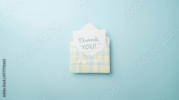 Obraz Thank you, message on white note card with blue, white, green and yellow plaid envelope on a matching blue background.
