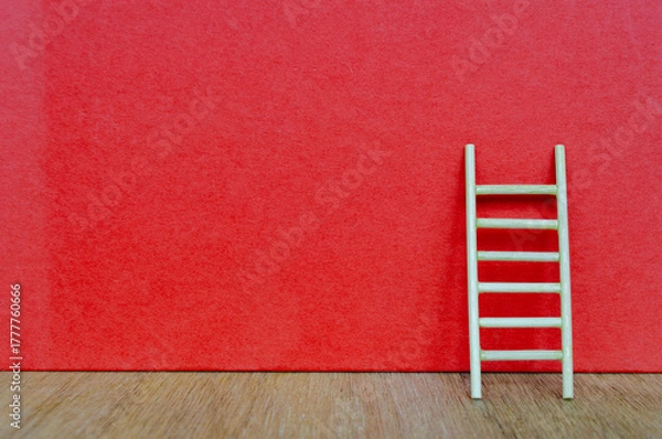 Obraz Small ladder on red cover background with customizable space for text.