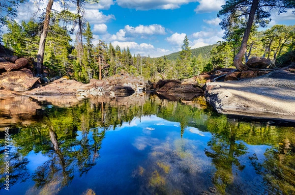 Fototapeta Calm reflective pool above Glen Alpine Falls near Fallen Leaf Lake at Lake Tahoe California USA with clear water mirroring pine forest rocky banks and blue sky in Sierra Nevada mountains on sunny day