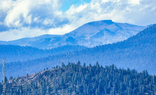 Fototapeta Mountain landscape near Lake Tahoe California USA with layers of forested hills and rugged Sierra Nevada peaks under dramatic cloudy sky scenic wilderness view and natural beauty