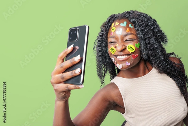 Fototapeta  Portrait of carefree woman with make up with stickers on face, taking selfie against colorful background. social media addiction, communication concept.