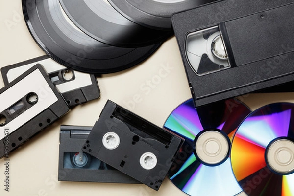 Obraz Texture of vintage retro vinyl records, retro acoustic, audio cassette tape, black video tape cassette, CD disc. Saving data, music, movies, videos. Vintage media concept. Top view. 