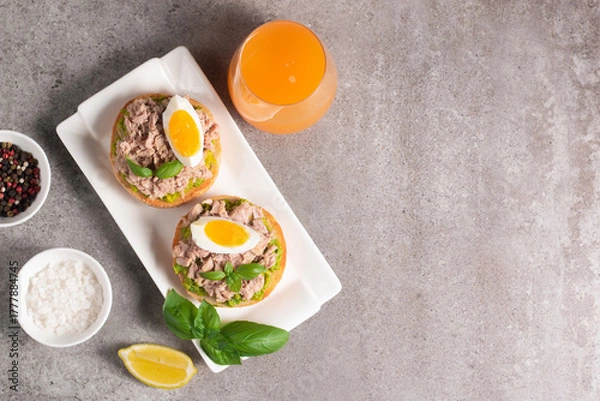 Obraz Two delicious tuna open sandwiches with avocado and boiled eggs. Tuna toast.