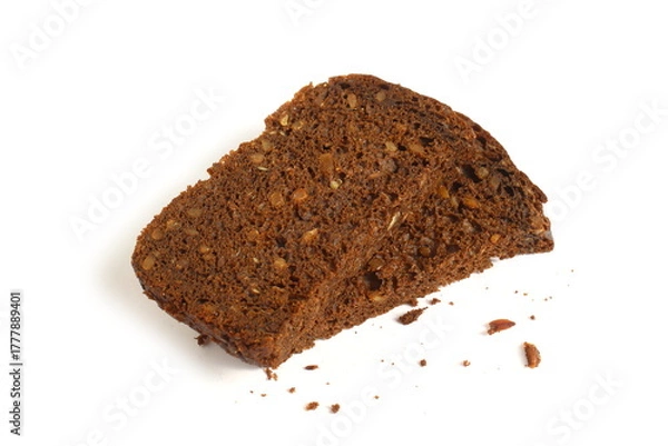 Fototapeta Pieces of black rye bread with sunflower seeds lie on a white background.	