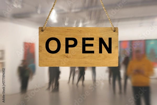 Obraz An "Open" sign against a blurred background of an interior with people