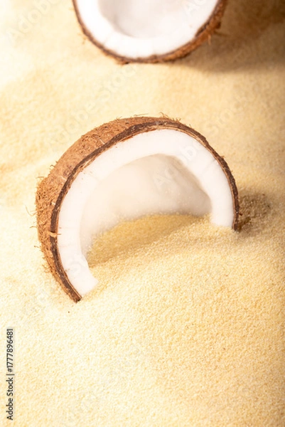 Fototapeta Cracked coconuts on sandy beach. Minimal summer tropical concept.